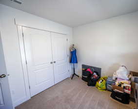 Bedroom featuring visible vents, a closet, and carpet floors