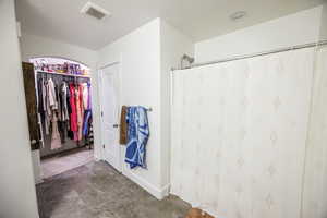 Bathroom with a shower with shower curtain and visible vents