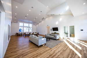 Living area featuring recessed lighting, french doors, light wood-type flooring, high vaulted ceiling, and visible vents