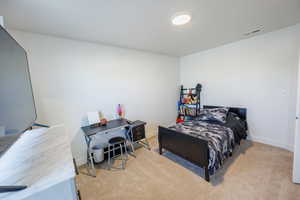 Bedroom featuring baseboards, visible vents, and carpet