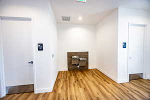 Interior space with baseboards, visible vents, light wood-style flooring, and recessed lighting