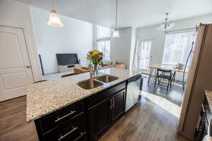 Kitchen featuring plenty of natural light, dark wood-type flooring, a sink, a kitchen island with sink, and appliances with stainless steel finishes