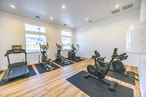Workout area with visible vents and wood finished floors