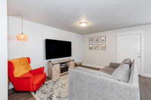 Living area with baseboards, visible vents, and wood finished floors