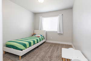 Carpeted bedroom with baseboards
