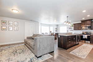 Living room featuring baseboards, light wood-style floors, and recessed lighting