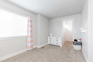 Large Bedroom featuring baseboards and light carpet, and walk in closet.