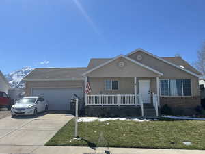 View of front of house featuring stucco siding, driveway, brick siding, a garage, and covered porch and tons of RV Parking