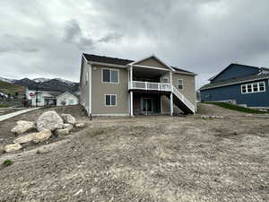 Back of property featuring a wooden deck and stairway