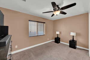 Interior space featuring baseboards, carpet, and a ceiling fan