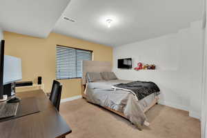 Bedroom with carpet floors, baseboards, and visible vents