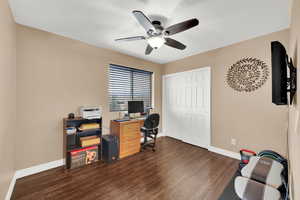 Office featuring baseboards, dark wood-style floors, and ceiling fan