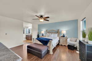 Bedroom with a sink, wood finished floors, ensuite bathroom, baseboards, and ceiling fan
