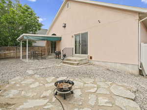 Back of house featuring an outdoor fire pit, stucco siding, fence, and a patio