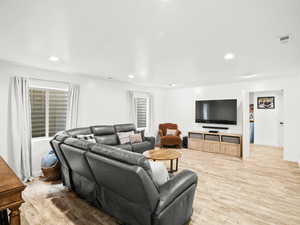 Living area featuring visible vents, light wood-style floors, and recessed lighting