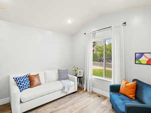 Living room featuring baseboards, lofted ceiling, and wood finished floors