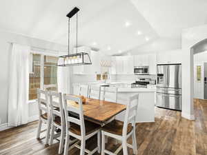 Dining room with vaulted ceiling, recessed lighting, baseboards, arched walkways, and light wood-style floors