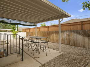 View of patio with a fenced backyard and outdoor dining area