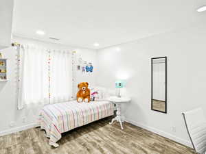 Bedroom featuring baseboards, wood finished floors, and recessed lighting