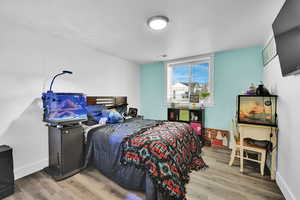 Bedroom with visible vents, baseboards, and wood finished floors
