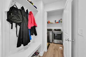 Mudroom with independent washer and dryer and wood finished floors