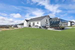 Back of property with an outdoor living space, a patio area, and a yard