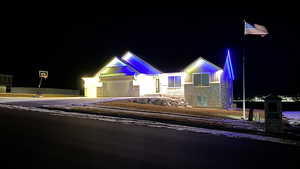 View of front facade featuring driveway, stone siding, and an attached garage