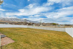 View of yard featuring a fenced backyard, a residential view, and a mountain view