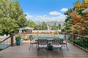 Deck with a mountain view, a fenced backyard, a gazebo, and a fenced in pool