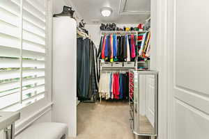 Spacious closet featuring carpet floors, attic access, and visible vents