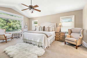 Bedroom featuring light colored carpet, a ceiling fan, baseboards, and vaulted ceiling