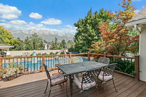 Wooden terrace with a fenced backyard, a fenced in pool, outdoor dining area, and a mountain view