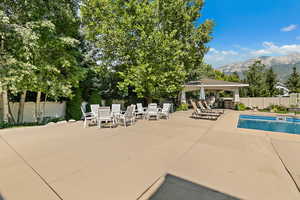 View of swimming pool featuring a fenced in pool, a fenced backyard, outdoor dining area, a mountain view, and a patio area
