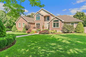 Traditional home with brick siding and a front lawn