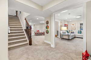 Interior space with stairs, recessed lighting, carpet, baseboards, and a textured ceiling