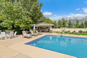 View of swimming pool with a fenced in pool, a gazebo, a fenced backyard, a patio, and a mountain view
