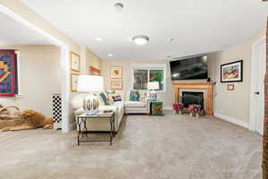 Living area with recessed lighting, carpet flooring, baseboards, a textured ceiling, and a fireplace