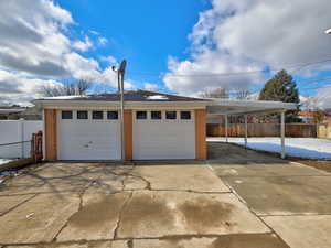 Garage featuring fence and a detached garage