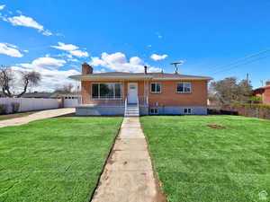View of front of home with a chimney, fence, a front lawn, and a porch