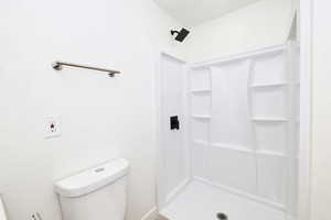 Full bathroom with a shower stall and toilet