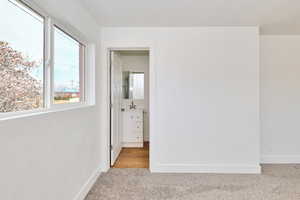 Spare room featuring baseboards and light carpet