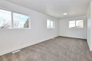 Carpeted spare room with baseboards and visible vents
