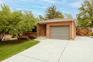Ranch-style home featuring driveway, brick siding, and a garage