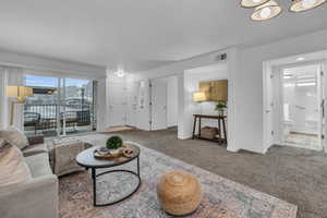 Carpeted living room with baseboards and visible vents