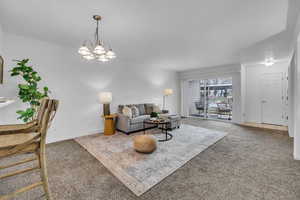 Living area featuring baseboards, carpet, and a chandelier