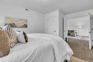 Bedroom with visible vents and carpet flooring