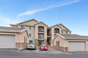 View of property featuring stairs, stucco siding, and stone siding