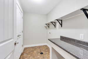 Walk in closet featuring stone finish floors
