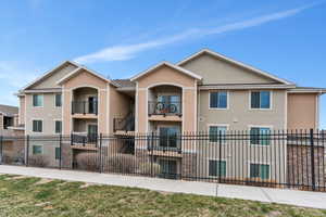 View of front facade featuring stucco siding and a fenced front yard