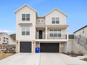 View of front of property with stairs, driveway, stone siding, an attached garage, and board and batten siding